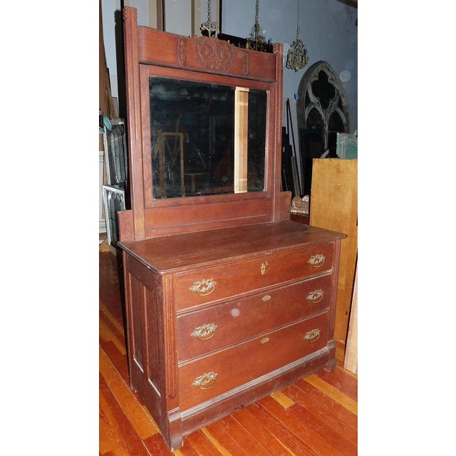 C. 1890 American oak three drawer bureau having tilting upper beveled glass mirror and original hardware.