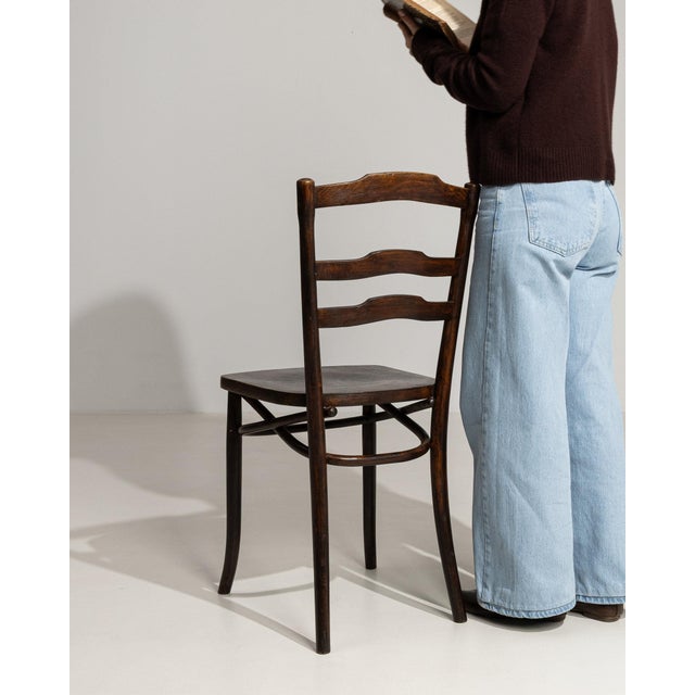 A dining chair whose dark ebonized wood, ladder back gives it real character at first glance. The piece dates to Early...