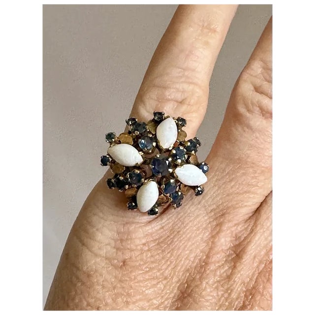 14k gold opal and sapphire ring. Gorgeous ring featuring a center sapphire flanked by four marquis cut opals and 20 small...