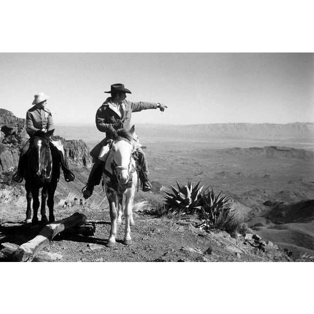 A striking image from the 1960s capturing two horseback riders overlooking the expansive desert landscape of Big Bend...