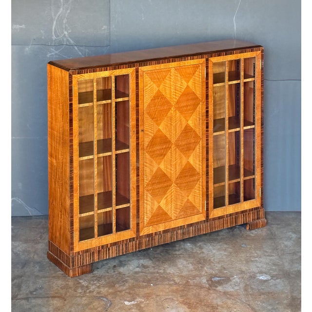 A period Art Deco Era display cabinet or bookcase from the 1930s, by the celebrated furniture makers, Heal's of London....