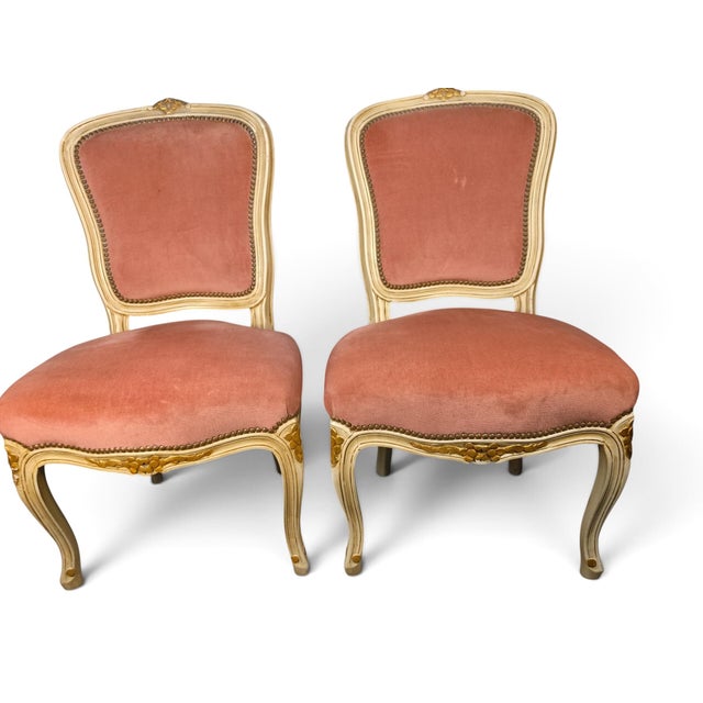 A charming pair of vintage French Provincial Louis XV-style accent chairs featuring gracefully carved cabriole legs, a...