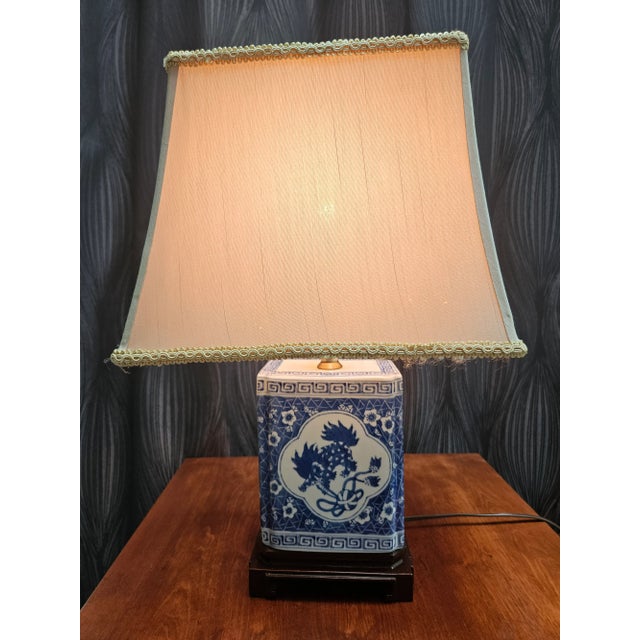 A fabulous blue and white Asian canister made into a lamp. Finished on a lovely wood base. Vintage rectangular shade is...