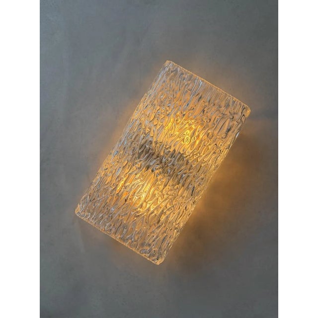 This sculptural wall lamp from the 1960s was manufactured by the Austrian company Kalmar Franken. The design is entirely...