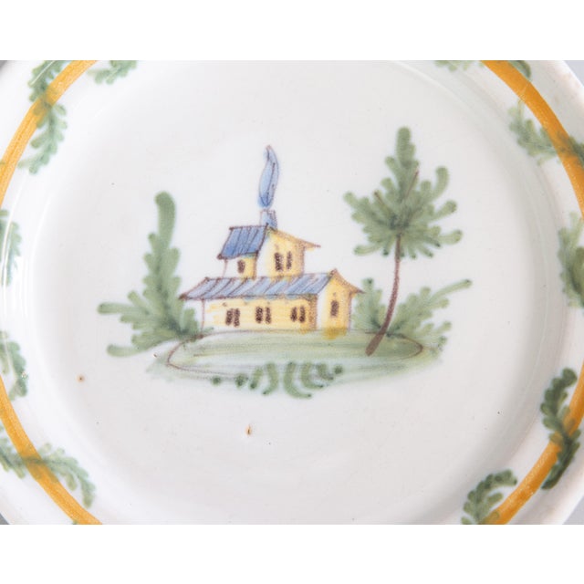 A lovely 18th century Nevers earthenware plate featuring a charming country home, smoke billowing out of the fireplace,...