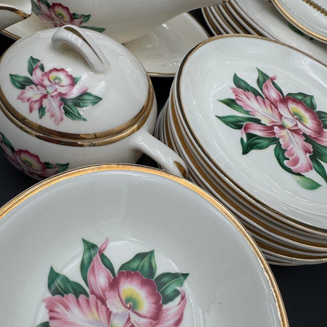 A beautiful vintage “Modern Orchid” china set by Paden City Pottery, featuring a stylized pink orchid bloom with lush...