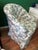 The chair is a classic upholstered club chair featuring a distinct floral print on a dot-patterned background. It is...