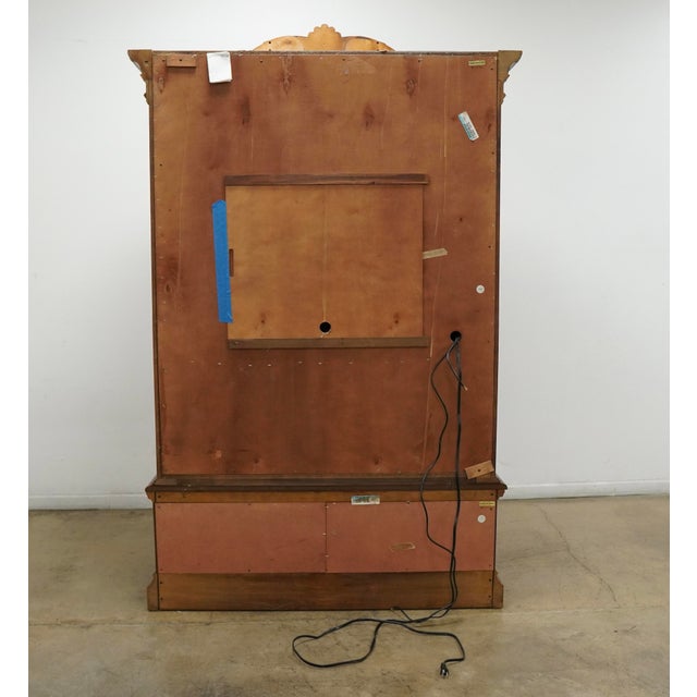 This vintage late 20th century armoire features richly figured burl veneers framed by sweeping Rococo-inspired carving and...