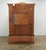 This vintage late 20th century armoire features richly figured burl veneers framed by sweeping Rococo-inspired carving and...