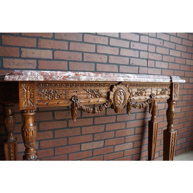 Antique French Louis XVI marble top console table. Intricately carved details including lovely swag adornment in the...