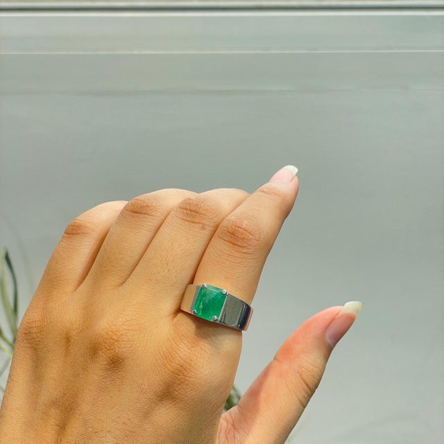 The Contemporary Wide-Band Octagon-Cut Green Emerald Statement Signet Ring features a striking 2.74 carat emerald in a...