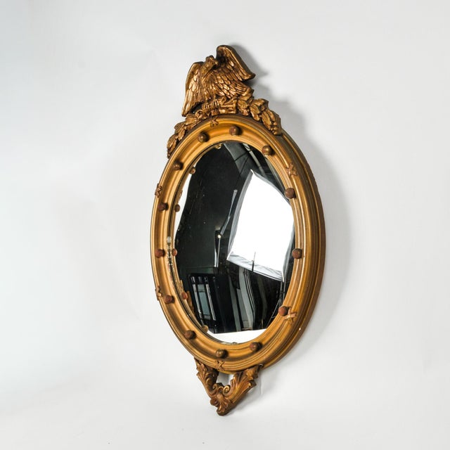 Fantastic large gilded wood convex glass eagle mirror. This butlery bullseye mirror features the perched American eagle...