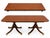 An elegant Baker Furniture heirloom dining table in the Georgian/Regency manner, featuring a banded mahogany top, carved...