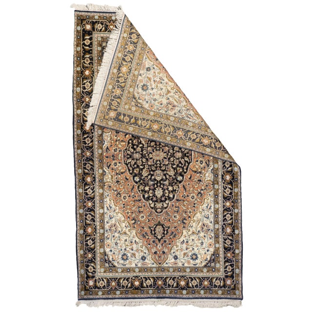 Persian silk rug from Qum, circa 1980. The rug features a central medallion set within a finely detailed floral field and...