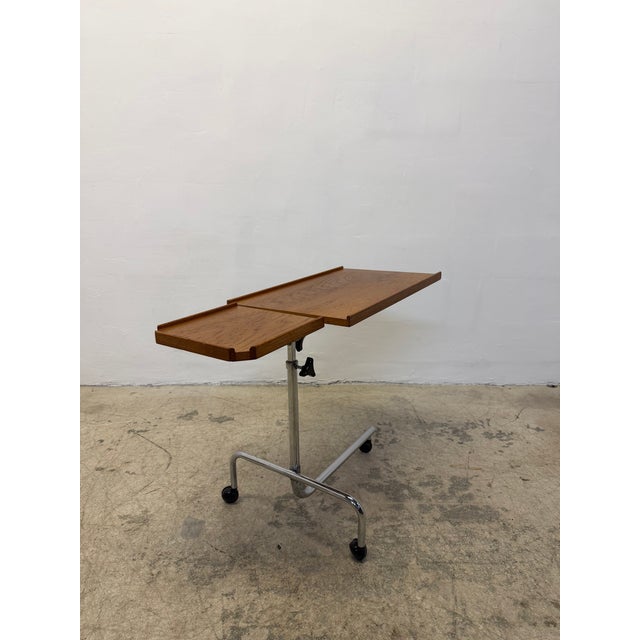 A Danish Modern adjustable table made of teak and polished chrome. Top tilts 90 degrees and has height adjustment from 25...