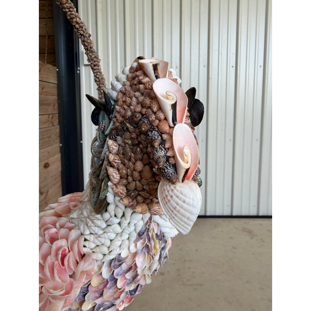 An extraordinary custom seashell-encrusted cockatoo sculpture, intricately created from an earlier papier-mâché bird and...