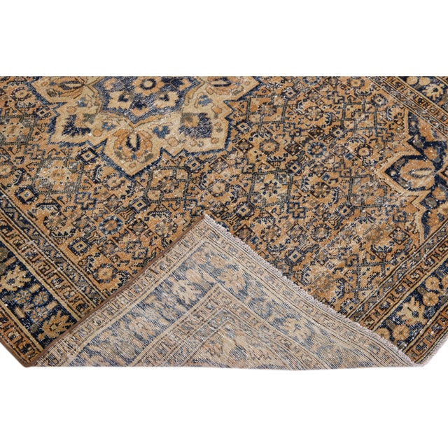 Beautiful vintage Persian distressed hand-knotted wool rug with a beige color field. This piece has navy blue and gray...