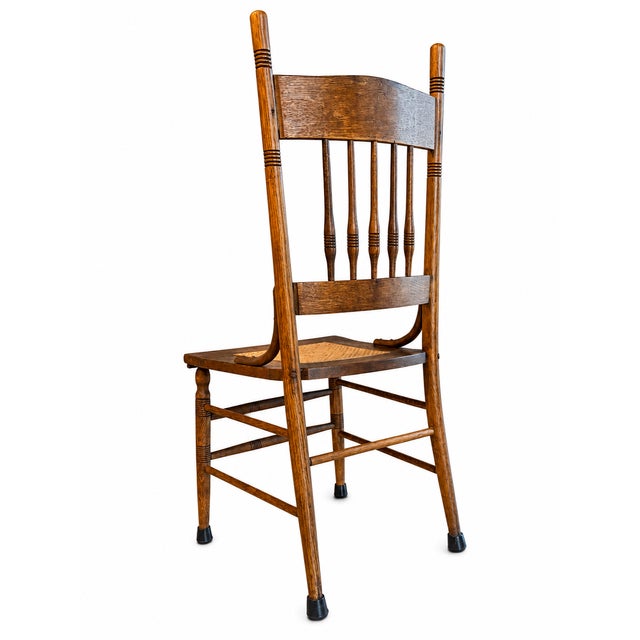 This classic antique pressed-back oak chair brings timeless late-19th-century American craftsmanship into the modern home....