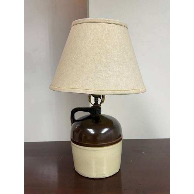 Design Plus Gallery presents a Vintage Rustic Two-Tone Ceramic Jug Table Lamp. The ceramic base has a rounded jug form...