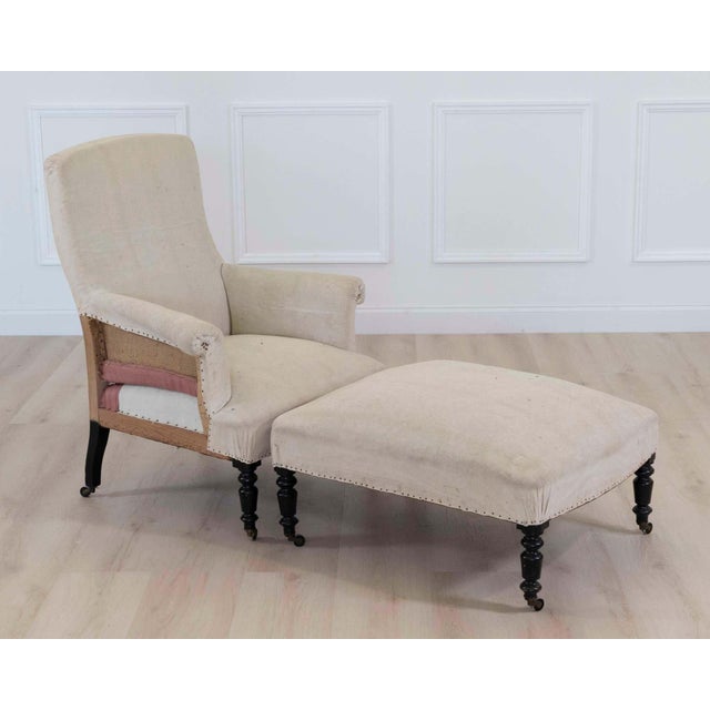 Elegant 19th century French Napoleon III armchair accompanied by its matching footstool, presenting a sophisticated...