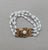 Hard to find 1960s goldtone 3-strand white ovoid bead with asian character with white rhinestone cabochon in the middle of...