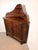 A charming antique oak corner cabinet featuring beautifully hand-carved panel doors, decorative floral motifs, and an...
