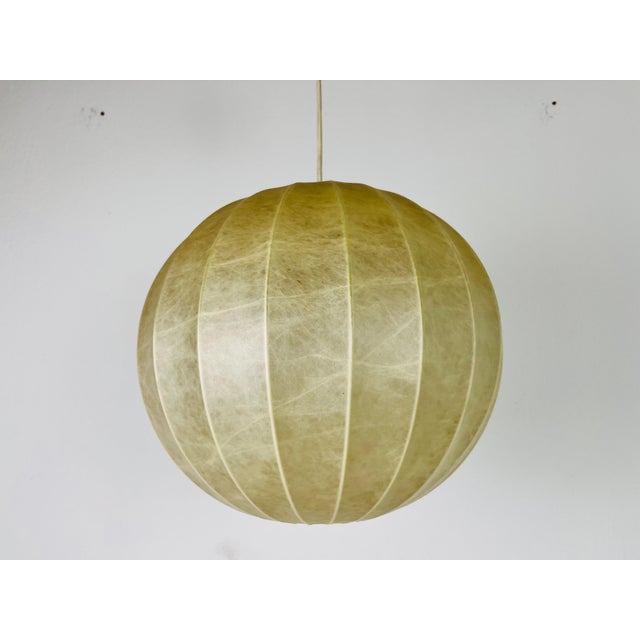 A cocoon hanging lamp made in Italy in the 1960s. It has a beautiful round design, which is similar to the lamps made by...