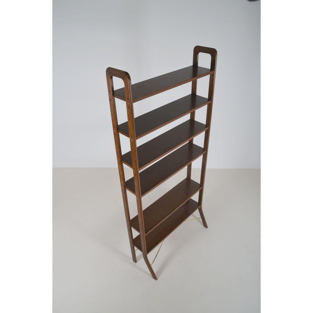 Danish freestanding wooden wall rack from the 1960s. This rack with brass accents has 6 height-adjustable shelves. The...