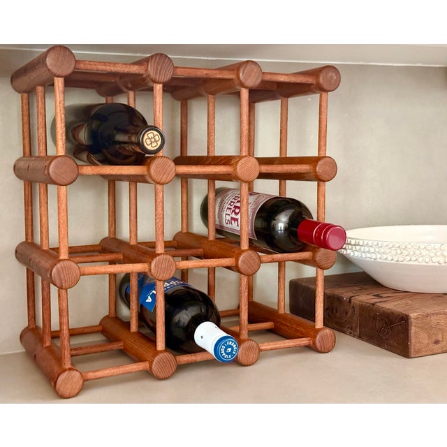 This versatile vintage wine rack is a mid-century modern design made of teak wood in the style of designer Richard Nissen...