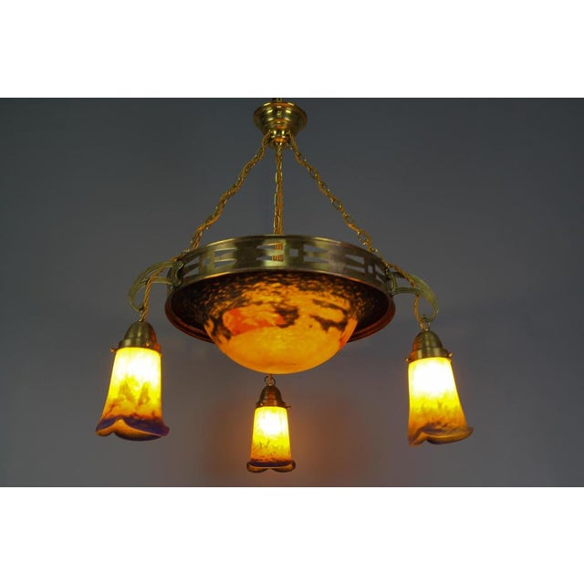 A beautiful four-light Art Nouveau brass pendant chandelier with Pâte de Verre glass by Noverdy. This impressive French...