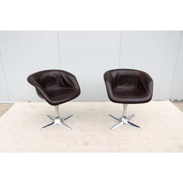 Striking pair of vintage mid-century modern split-seat swivel bucket chairs upholstered in fabulous distressed dark brown...