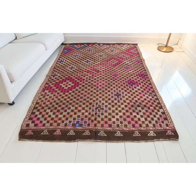 This is a vintage Turkish Oushak rug from the Mid 20th Century. The piece was hand-knotted.