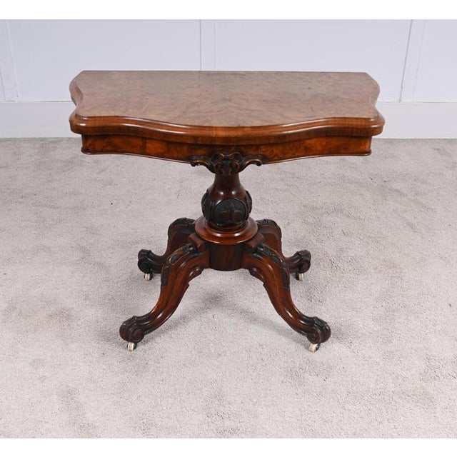 Fine quality English Victorian walnut card table with elegant fold-over action The shaped top opening to reveal a green...