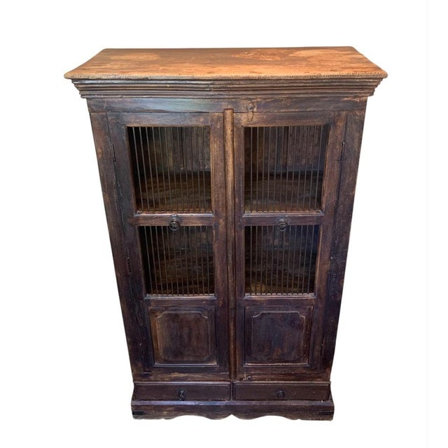 Beautiful antique storage bird cage style wooden cabinet with metal spindle front doors and two storage drawers below....