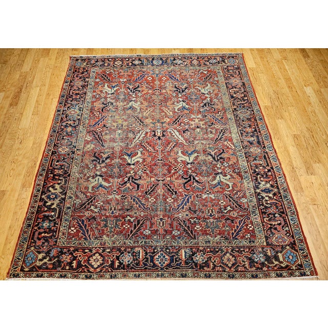 "A masterful example of early 20th century Persian craftsmanship, this rare antique Heriz Serapi rug features an uncommon...
