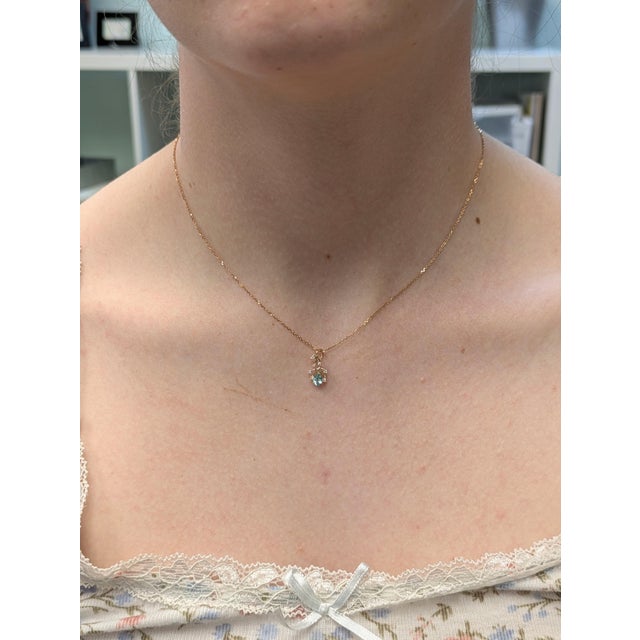 This delicate pendant features a 0.22-carat Afghan tourmaline (5x3mm) at its center, exuding a beautiful natural color....