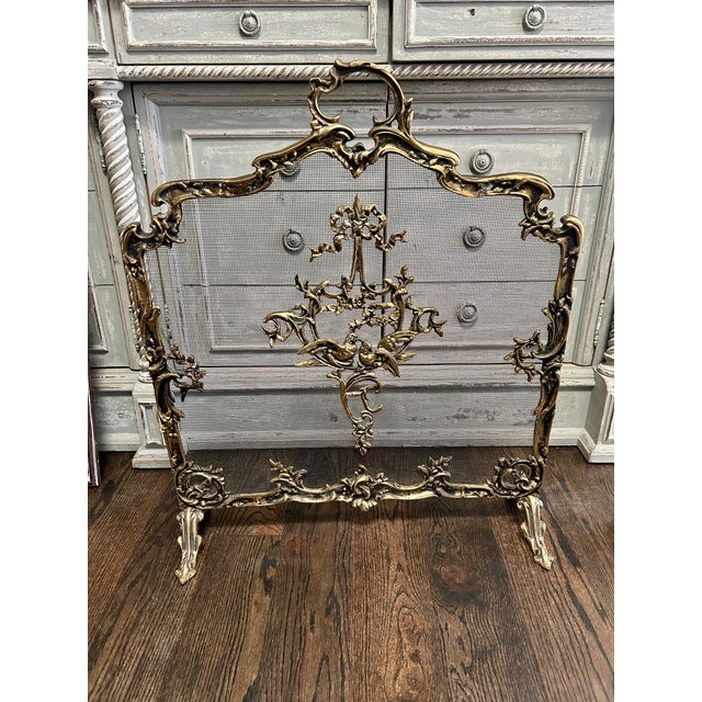 A beautifully detailed vintage fireplace screen in the French Rococo taste, featuring an ornate scrolling frame with a...