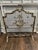 A beautifully detailed vintage fireplace screen in the French Rococo taste, featuring an ornate scrolling frame with a...