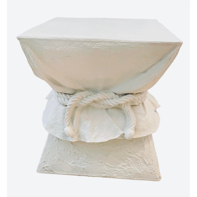 A striking trompe-l’oeil pedestal table designed to mimic softly draped fabric gathered with a rope tie—an iconic design...