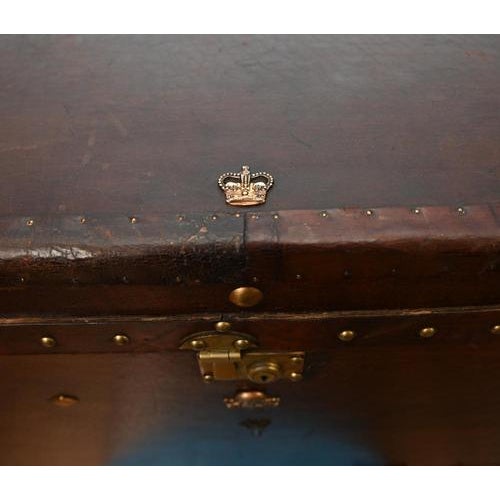 A classic vintage leather travel trunk, beautifully aged with a rich, deep patina that reflects years of use and travel...