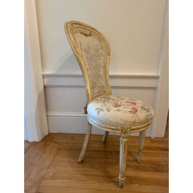 Beige, cane back Louis XVI accent chair with upholstered seat featuring blush roses. This chair has a tall, stately back,...