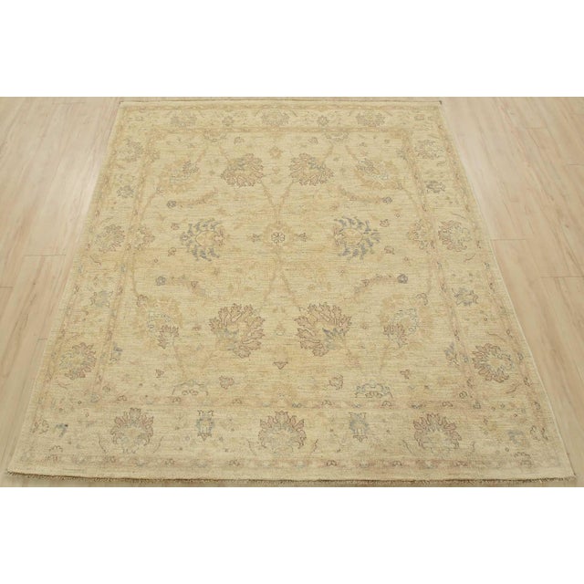 A traditional Ziegler rug hand-knotted with an all-wool pile on a cotton foundation. This oriental rug features muted...