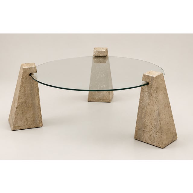 Travertine and glass coffee table. It features a glass top with some signs of wear, scratches, and a small chip that can...
