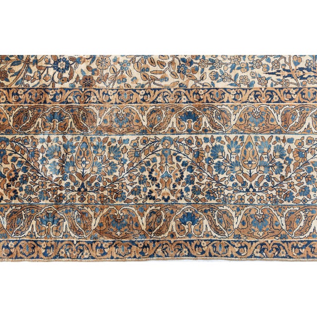 An early 20th century Persian Kirman (Kerman) antique rug, the cream field with an allover compact design of flowering...