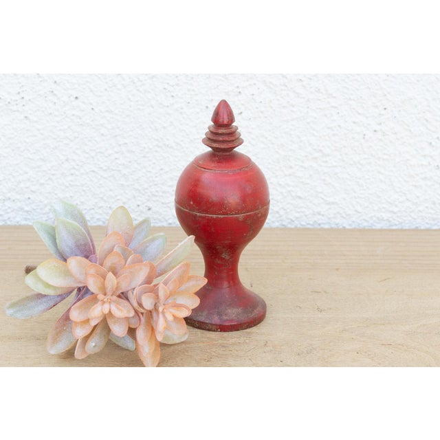 A captivating piece of devotional carpentry, this turned wooden container is shaped like an architectural finial or temple...