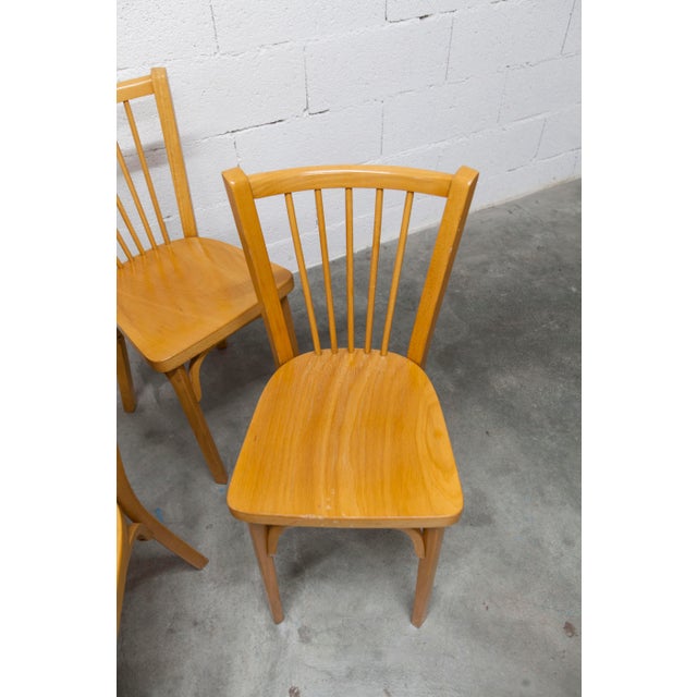 Set of four Baumann bistro chairs, model 153, stamped 1981. These beechwood chairs boast a timeless and elegant design,...