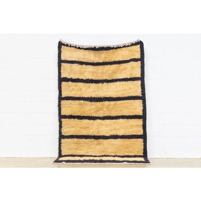 This vintage handwoven Anatolian wool floor rug features an abstract, minimalist design with an open beige field and...
