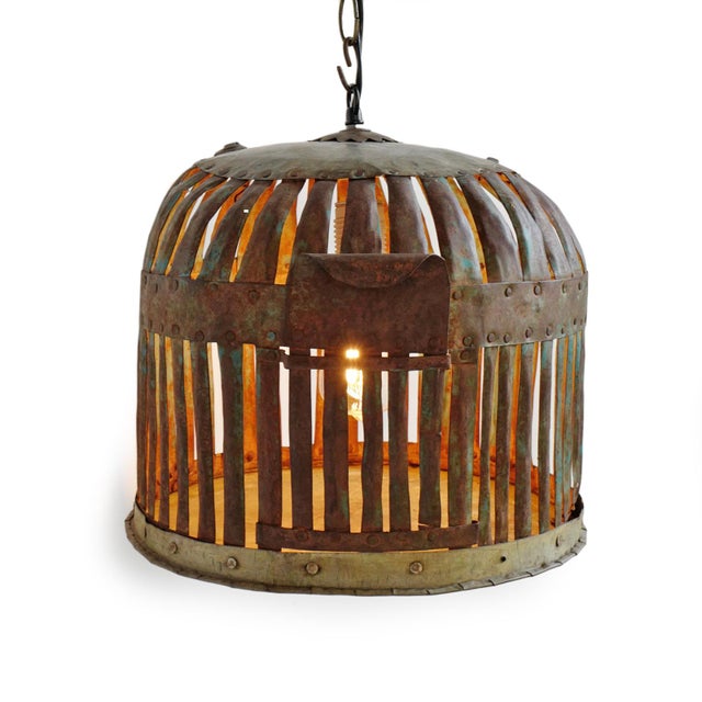 Vintage Indian iron cage basket thoughtfully repurposed into a one-of-a-kind pendant light, celebrating the raw beauty of...