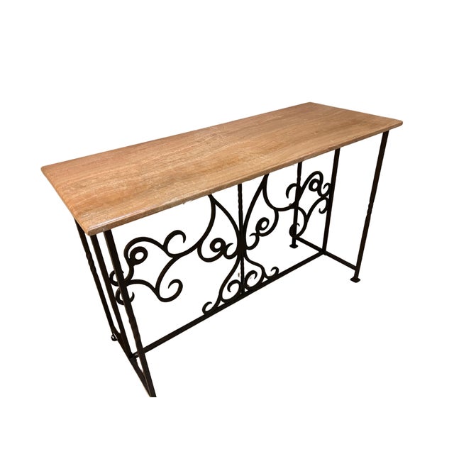 Decorative vintage console / credenza table featuring a rectangular natural marble top resting on an elegant wrought iron...