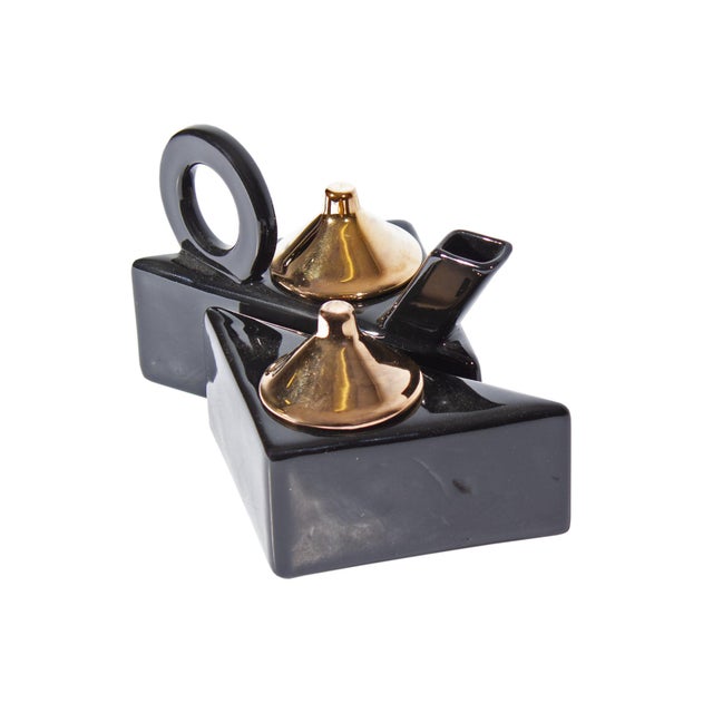 A Postmodern creamer and sugar set by Feltman Langer. This pair features glossy black bodies with gold tone lids. Both the...